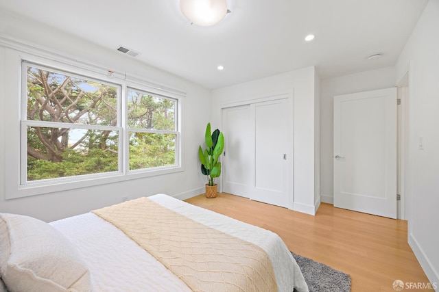 bedroom featuring baseboards, visible vents, light wood-type flooring, a closet, and recessed lighting