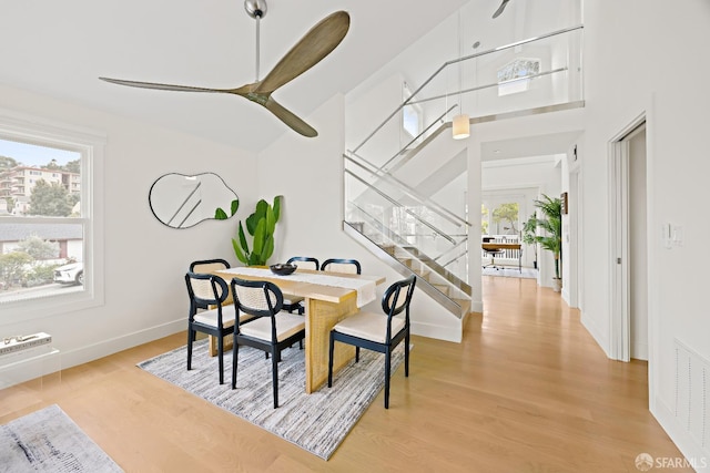 dining room featuring a healthy amount of sunlight, visible vents, light wood finished floors, and stairs