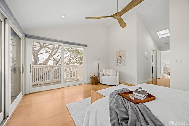 bedroom featuring a skylight, light wood-style flooring, a ceiling fan, access to outside, and baseboards