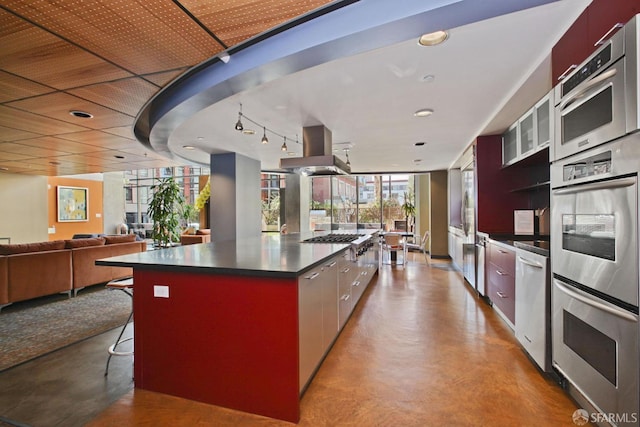 170 King St Unit 1006, San Francisco, CA 94107 - kitchen with island range hood, modern cabinets, appliances with stainless steel finishes, dark countertops, and a kitchen island