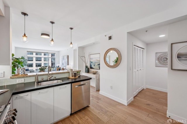 170 King St Unit 1006, San Francisco, CA 94107 - kitchen featuring dishwasher, dark countertops, light wood-type flooring, hanging light fixtures, and white cabinetry