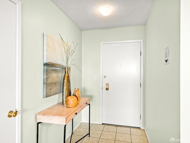 doorway featuring light tile patterned floors and a textured ceiling