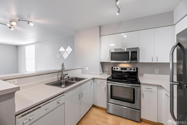 8100 Oceanview Ter Unit 117, San Francisco, CA 94132 - kitchen with stainless steel appliances, a sink, track lighting, white cabinets, and light wood finished floors