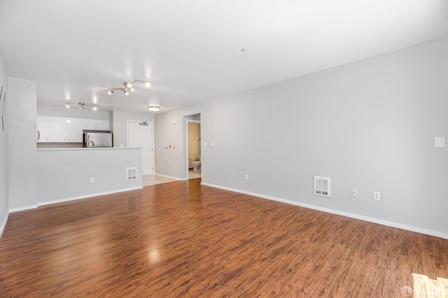 8100 Oceanview Ter Unit 117, San Francisco, CA 94132 - unfurnished living room with wood finished floors, baseboards, and track lighting