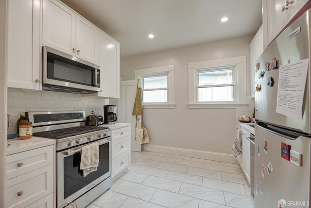 kitchen featuring white cabinetry, appliances with stainless steel finishes, and decorative backsplash