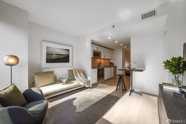 living room featuring sink and light hardwood / wood-style floors