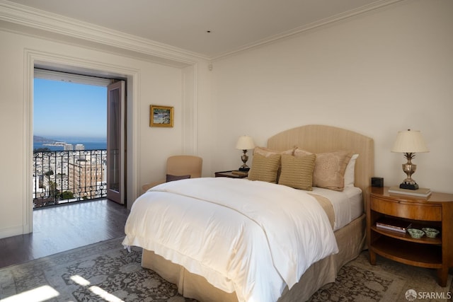 bedroom with crown molding, dark hardwood / wood-style flooring, a water view, and access to outside