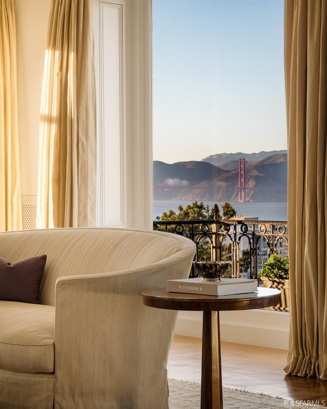 sitting room with a mountain view, wood-type flooring, and a wealth of natural light