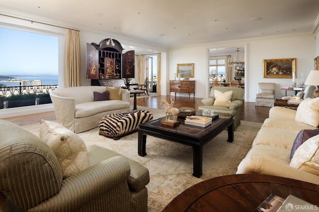 living room with light hardwood / wood-style floors, a water view, and ornamental molding