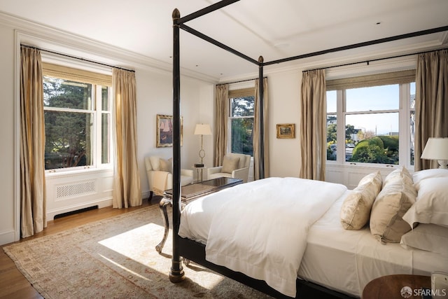 bedroom featuring hardwood / wood-style floors and crown molding