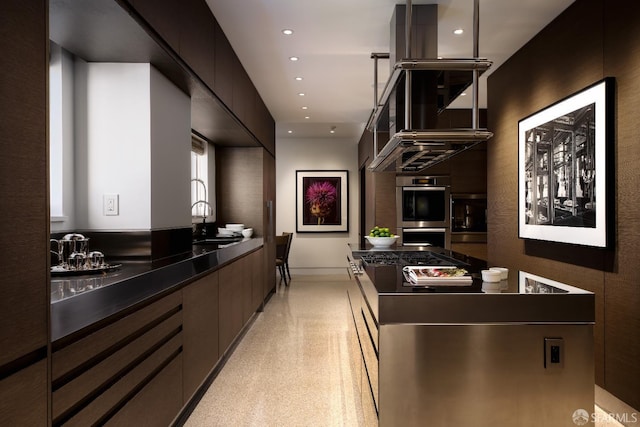 kitchen featuring decorative light fixtures, sink, stainless steel double oven, and dark brown cabinets