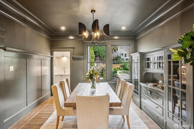 dining room with light wood-style floors, an inviting chandelier, recessed lighting, and crown molding