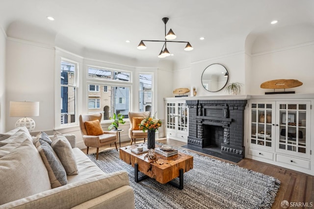 living room featuring recessed lighting, a fireplace, and wood finished floors