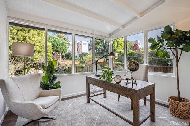 sunroom / solarium featuring vaulted ceiling with beams