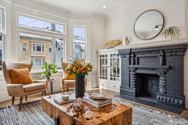 living area with a fireplace, baseboards, and wood finished floors