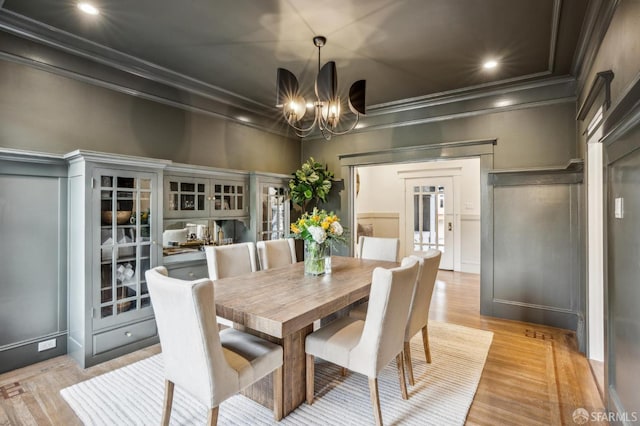 dining space with ornamental molding, recessed lighting, a chandelier, and light wood finished floors