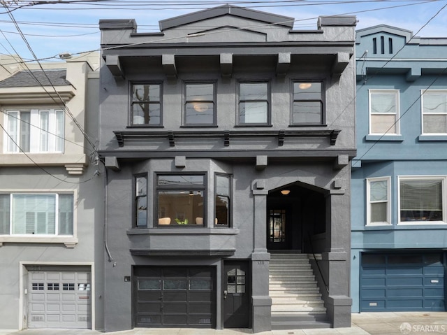 multi unit property featuring an attached garage and stucco siding