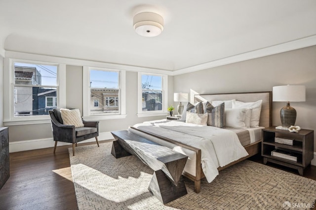 bedroom with multiple windows, ornamental molding, dark wood-style flooring, and baseboards