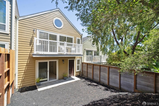 back of house featuring a balcony and a patio