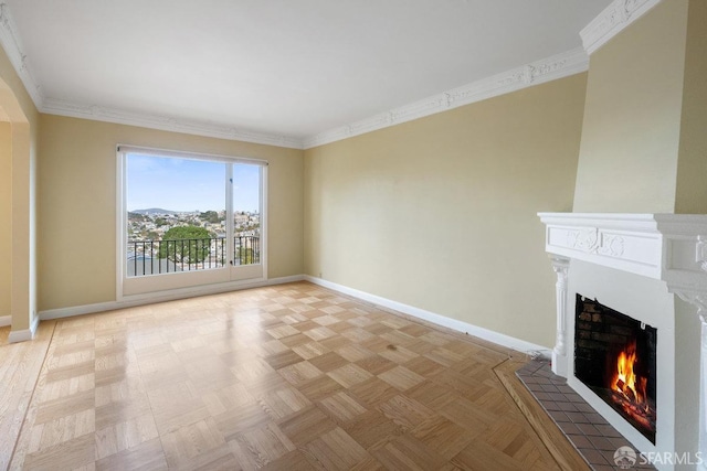 unfurnished living room with crown molding, a tile fireplace, and light parquet flooring