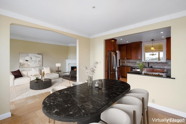 dining room with ornamental molding and sink