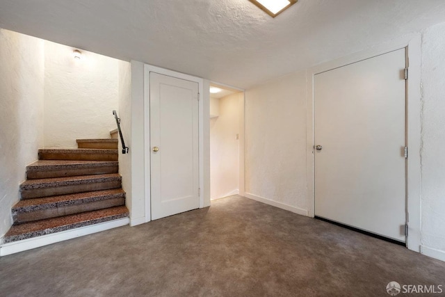 basement with dark carpet and a textured ceiling