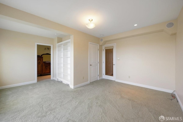 empty room featuring light carpet and built in features