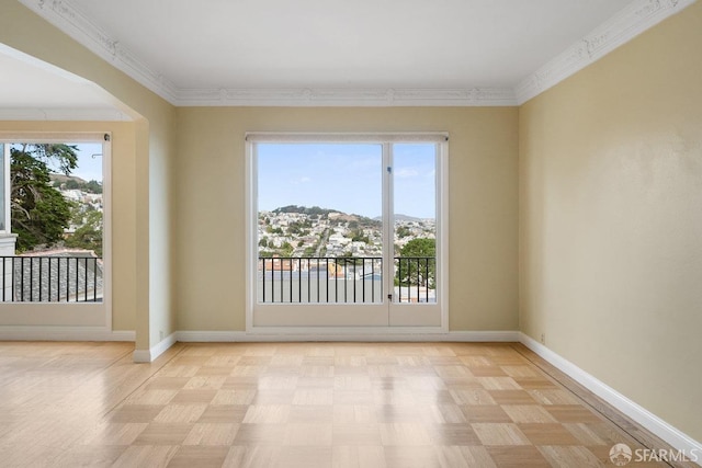 unfurnished room with a mountain view, crown molding, and light parquet floors