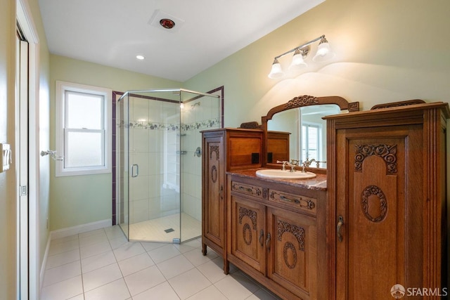 bathroom featuring vanity, a shower with shower door, tile patterned floors, and a healthy amount of sunlight