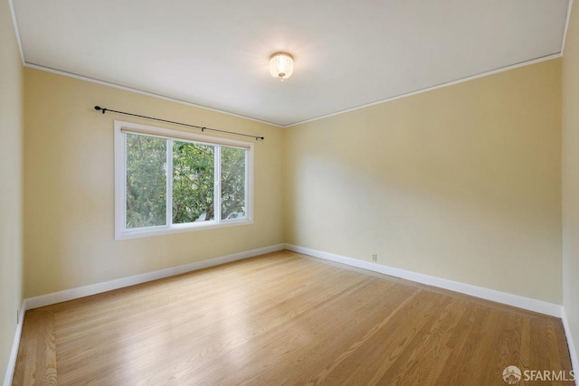 empty room featuring crown molding and light wood-type flooring