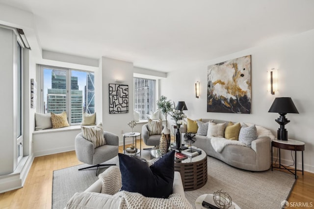 living room with a view of city, light wood-style flooring, and baseboards