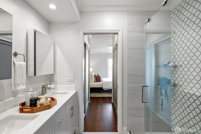 full bath with crown molding, a stall shower, wood finished floors, ensuite bath, and double vanity