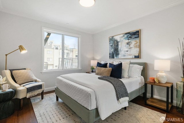 bedroom featuring wood finished floors, crown molding, and baseboards