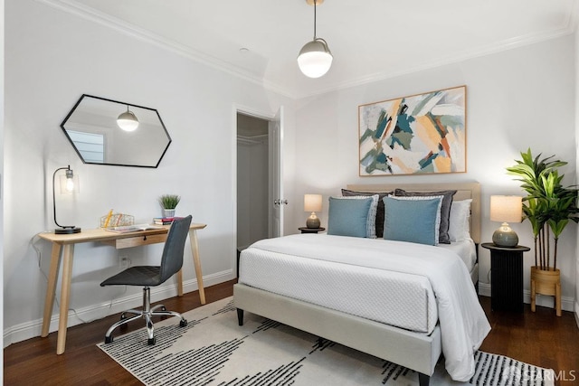bedroom with wood finished floors, crown molding, baseboards, an office area, and a closet