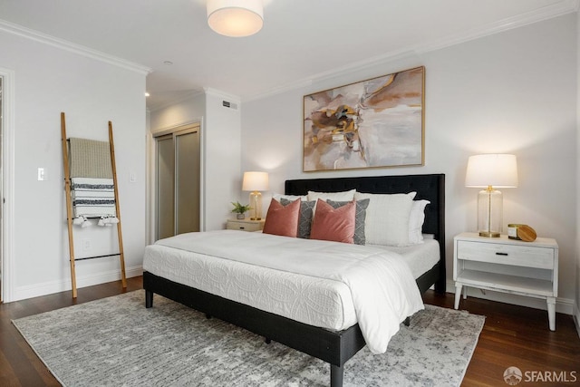 bedroom featuring ornamental molding, wood finished floors, a closet, and baseboards