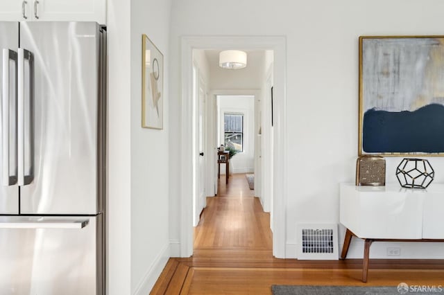 corridor featuring baseboards and visible vents