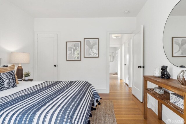 bedroom with baseboards and wood finished floors