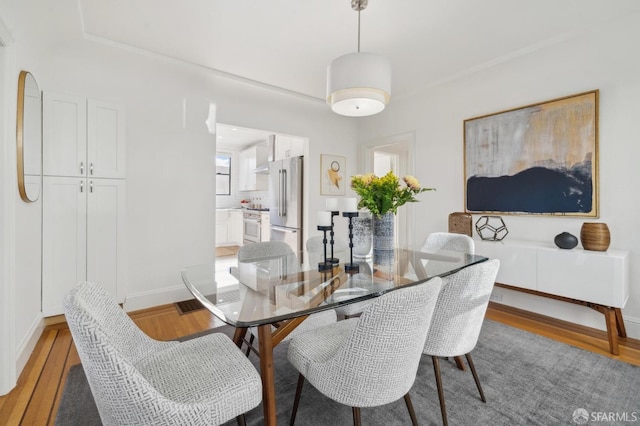 dining room with light wood finished floors and baseboards