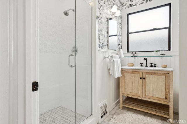 full bathroom with a stall shower, wainscoting, visible vents, and vanity