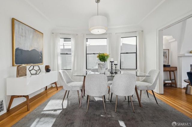 dining space with baseboards and wood finished floors