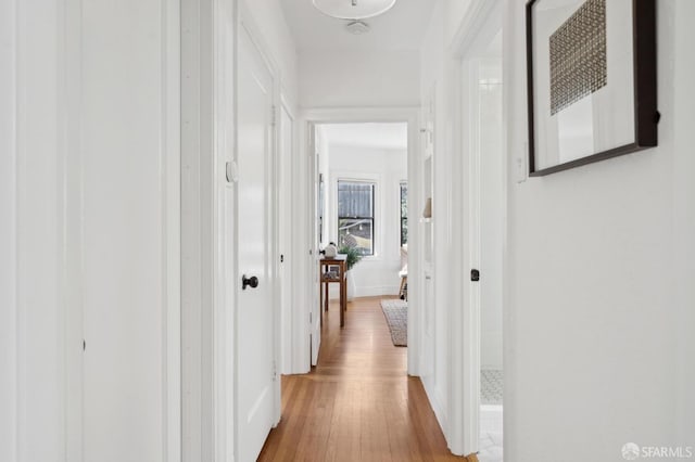 corridor featuring baseboards and wood finished floors