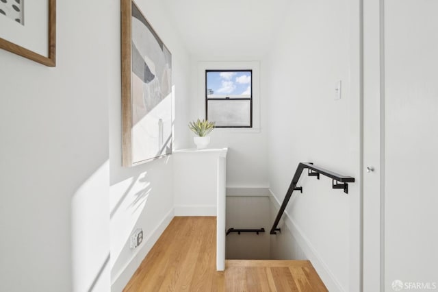 stairs featuring wood finished floors and baseboards