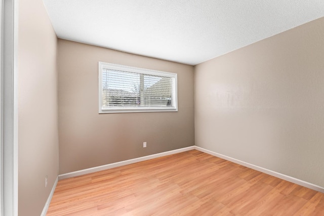 spare room featuring a textured ceiling and light wood-type flooring