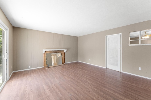 unfurnished living room featuring a brick fireplace and hardwood / wood-style floors