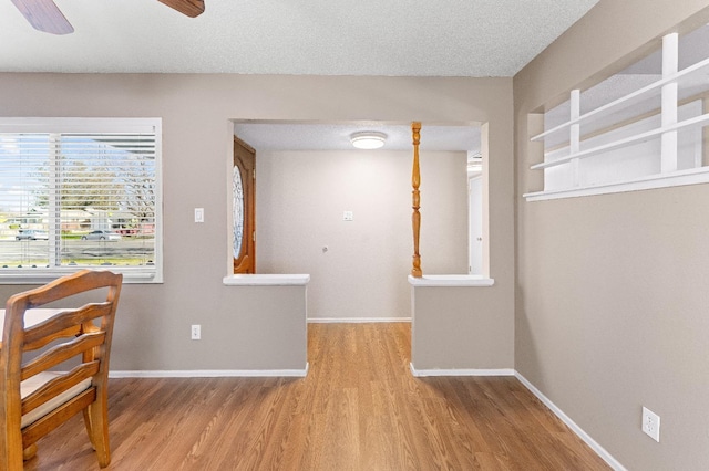 interior space with ceiling fan, light wood-type flooring, and a textured ceiling