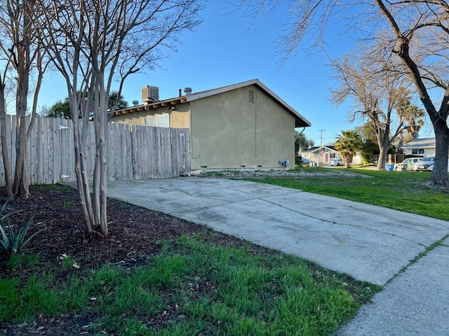 view of property exterior featuring a lawn and central air condition unit