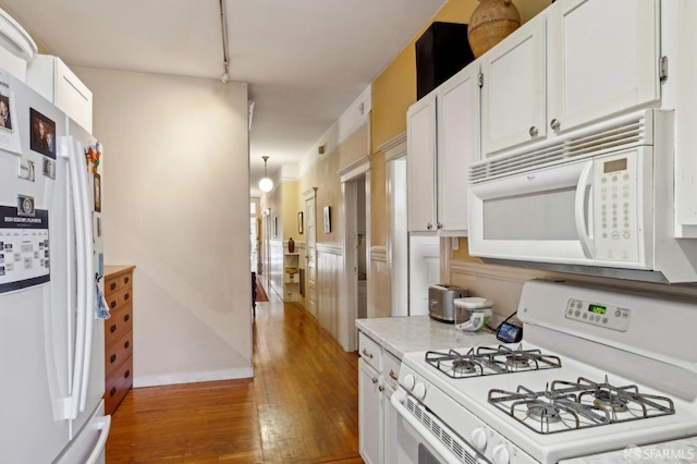 157-167 Vicksburg St, San Francisco, CA 94114 - kitchen featuring white appliances, wood finished floors, white cabinets, light countertops, and baseboards