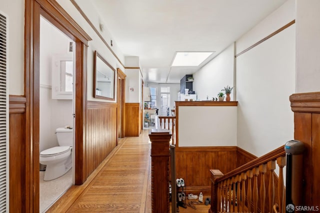 157-167 Vicksburg St, San Francisco, CA 94114 - corridor featuring a wainscoted wall, an upstairs landing, a skylight, and light wood-type flooring
