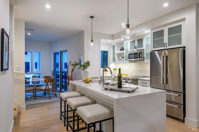kitchen with appliances with stainless steel finishes, visible vents, recessed lighting, and light wood-style floors