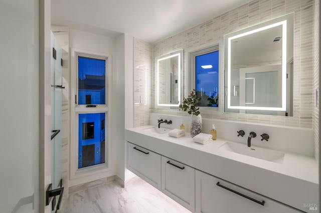 bathroom with double vanity, marble finish floor, and a sink